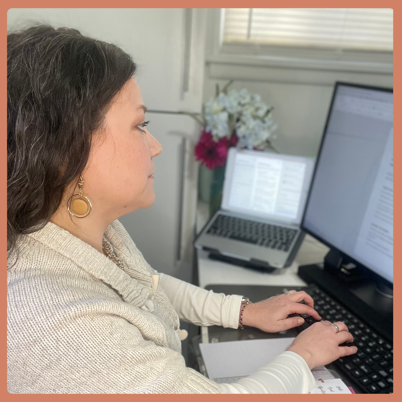 Christy sits at her desk, typing on the computer.